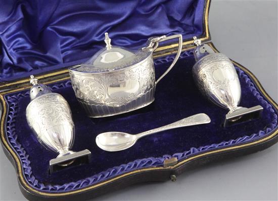 A cased late Victorian engraved silver three piece condiment set and spoon by Josiah Williams & Co, London, 1897/9.